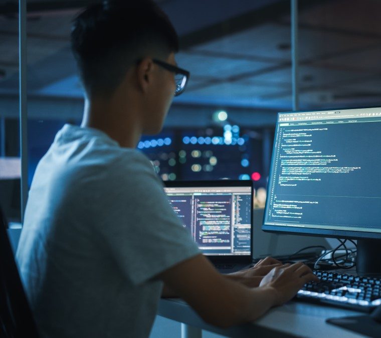 expert en cybersécurité analysant des écrans de code pour protéger les systèmes