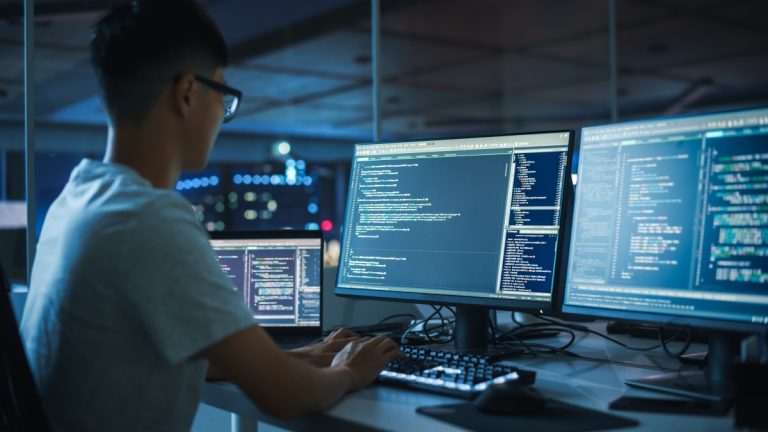 expert en cybersécurité analysant des écrans de code pour protéger les systèmes